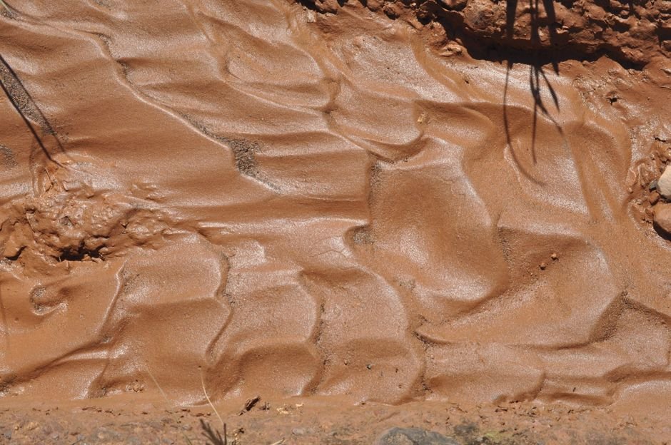 Wet natural clay soil with a rippled surface, the raw material behind how is clay made