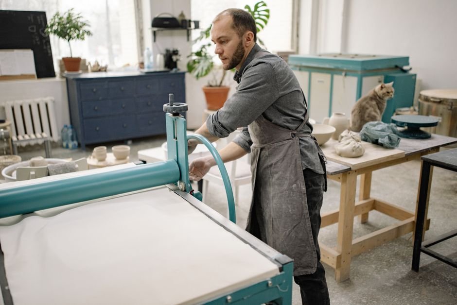Potter working with equipment in a ceramics studio, part of the daily reality of ceramic artist jobs