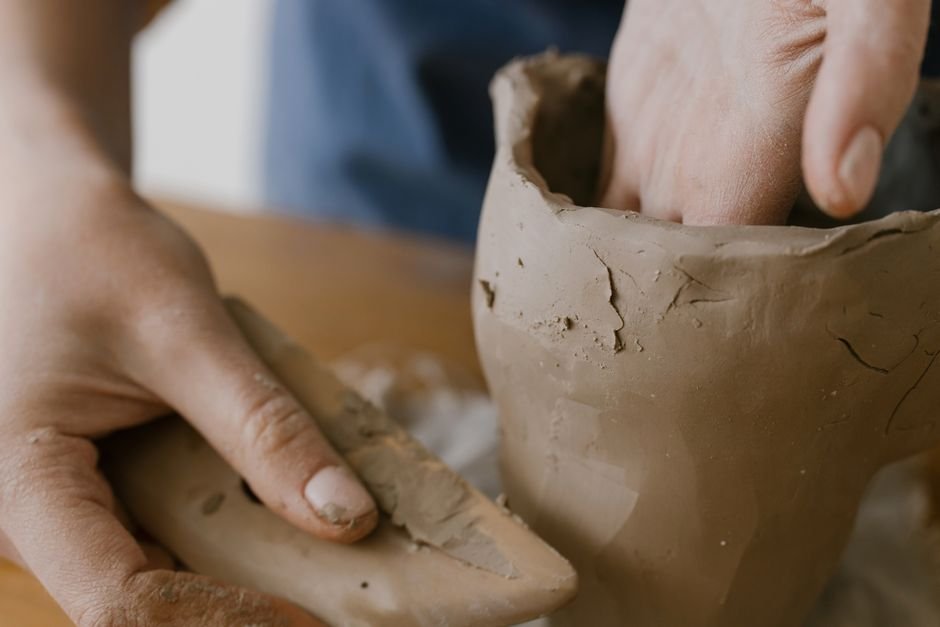 Hands shaping a small clay pot, one of the simplest beginner easy clay models to try