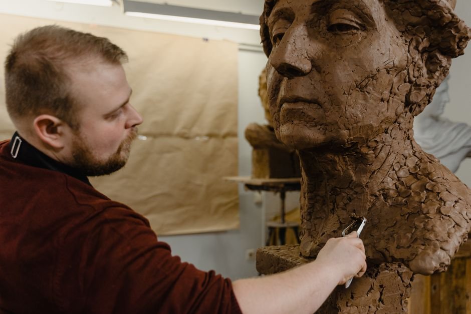 Artist sculpting a detailed clay bust with a sculpting clay suited to fine work