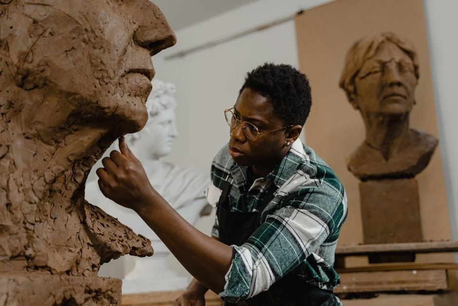 Artist shaping a clay head, a classic example of what makes a sculpture a sculpture