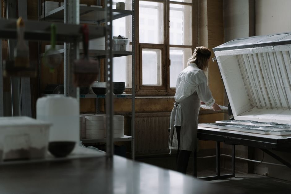 Ceramic artist working in a studio with a kiln, where pottery cone numbers guide every firing