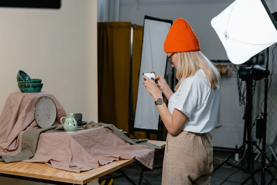 Maker photographing ceramic pieces in a studio, a key skill in ceramic artist jobs