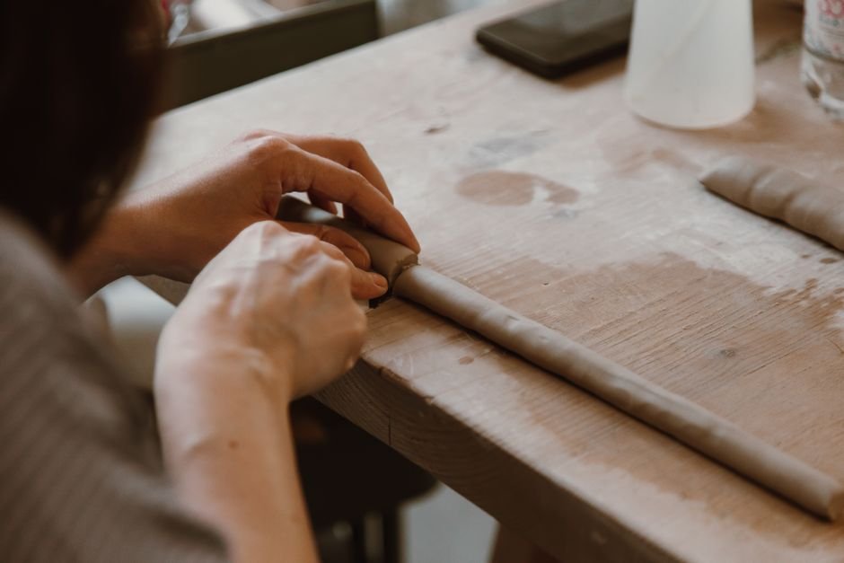 Hands sculpting a freeform clay piece, the first step toward abstract ceramic art